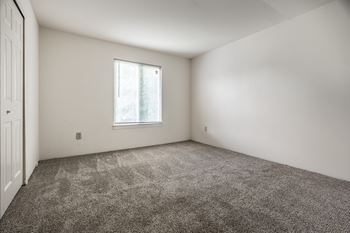 A room with a carpeted floor and a window